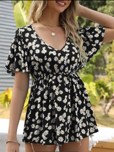 Black V-neck floral summer top with daisy prints and ruffle sleeves outdoors