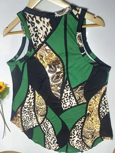 Detail of sleeveless stand collar top with green geometric, leopard, and baroque patterns