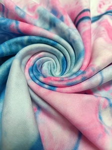 Detailed macro view of soft pink and blue tie-dye fabric with premium knit texture