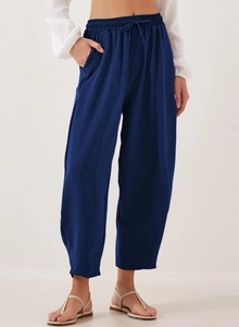 Detail of high waist dark blue trousers showing drawstring waist and pockets on linen fabric