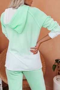 Rear view of woman in light green and white color-block hoodie and matching jogger set