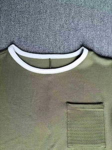 Detail of army green waffle knit texture with white ringer collar and square pocket