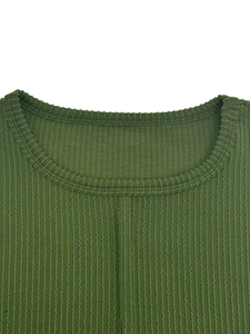 Détail du tissu en maille côtelée vert foncé avec texture verticale et col rond ajusté