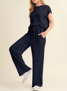 Vue détaillée de la texture en maille côtelée bleu foncé sur l'ensemble haut et pantalon