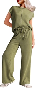Détail du tissu en maille côtelée vert olive sur le pantalon large et le haut assorti