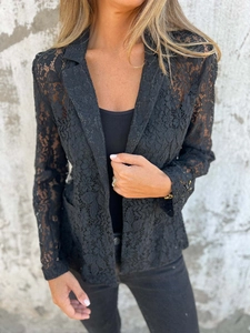 Detail of elegant black hollow lace blazer featuring classic lapels and intricate patterns