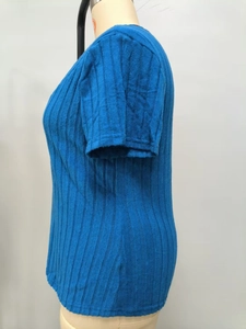 Detalle de la textura del tejido de punto acanalado en un top azul marino de manga corta
