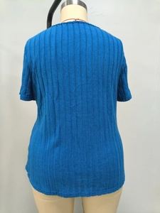 Vista posterior de un top azul de punto acanalado de manga corta en un maniquí