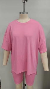 Detail eines rosa Lounge-Sets mit lockerem T-Shirt und elastischen Radlershorts