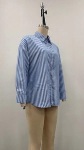 Détail du col à revers et du motif à rayures verticales bleues sur une chemise en coton