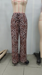 Detailed close-up of leopard print wide-leg trousers with elastic drawstring waist design
