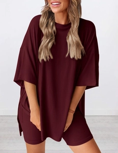 Detail eines dunkelroten Oversize-Lounge-Sets mit Seitenschlitz und weichem Strickstoff