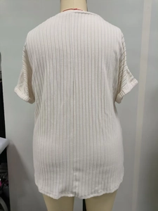 Detail of ribbed knit cream short sleeve top showing back vertical seam and rolled cuffs