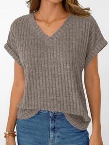 Detail of V-neck knitted top showing vertical ribbed texture and soft grey fabric