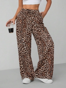 Detail of high-waist elastic drawstring waistband on leopard print wide-leg trousers
