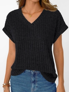 Close-up of black V-neck short sleeve knit top showing ribbed texture and rolled cuffs