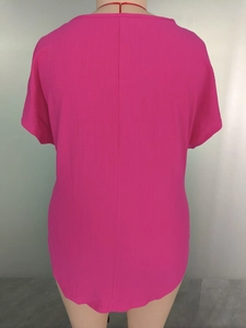 Detail of rose pink short-sleeved top showing vertical fabric texture and back seam