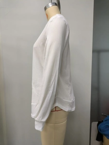 Detail view of white waffle knit sweatshirt with curved hem and ribbed cuffs on a mannequin