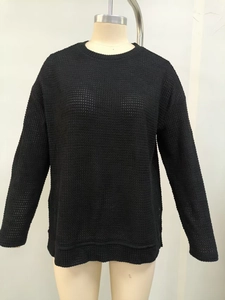 Dettaglio della trama in maglia a nido d'ape nera su un top casual a maniche lunghe