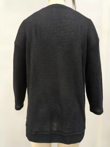 Vista posteriore dettagliata del top in maglia a nido d'ape nera con vestibilità ampia