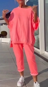 Detailansicht von pinkfarbenem Oversized-Sweatshirt und Jogginghose auf einer Terrasse