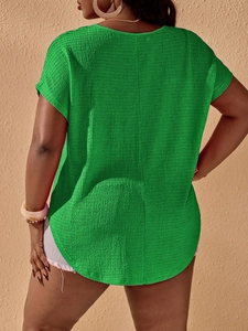Detail of plus size green t-shirt with textured fabric and curved hem design