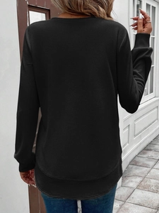 Detail view of the black waffle knit long sleeve top with a curved hem and ribbed cuffs