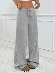 Detail of grey ribbed knit wide leg pants showing drawstring waist and vertical texture