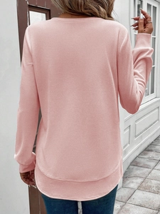 Detail of pink waffle knit sweatshirt showing layered hem and soft fabric texture