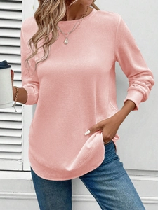 Close-up of women's pink waffle knit long sleeve sweatshirt with crew neck and curved hem