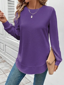 Detail view of purple waffle texture fabric and curved hemline on women's long sleeve top