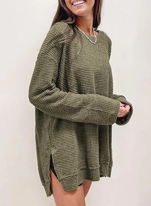 Dettaglio della trama a nido d'ape verde militare e spacco laterale sulla maglia