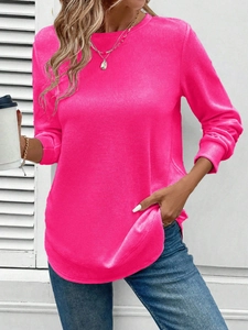 Detail of waffle knit fabric and curved hem on a hot pink long sleeve crewneck top