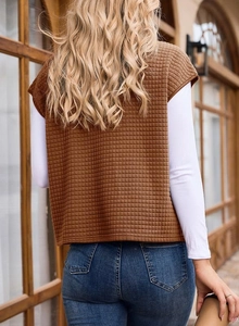 Macro detail of brown quilted waffle texture on oversized sleeveless vest jacket for women