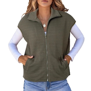 Detail of dark green quilted vest featuring waffle texture, zipper and side pockets