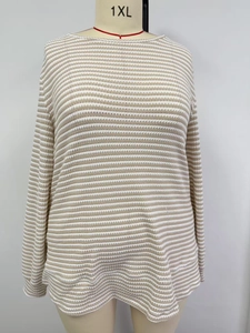 Detalle de la textura de punto calado y el patrón de rayas beige en el jersey de cuello redondo