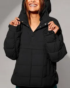 Close-up of black oversized quilted hoodie with metallic snap buttons and matte texture