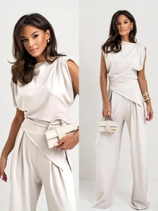 Détail de l'ensemble beige élégant avec haut drapé et pantalon large à taille haute