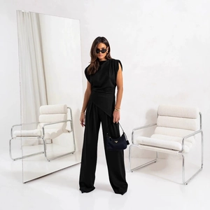Détail du haut sans manches noir à ourlet asymétrique et du pantalon large élégant