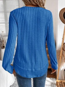 Detail of blue ribbed knit texture and slim fit long sleeve design on a crewneck sweater