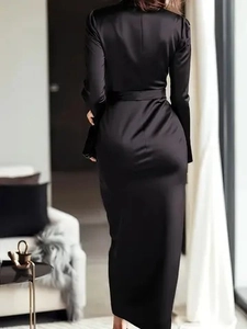 Detail of elegant black satin long sleeve dress showing slim waist tie and premium drape texture