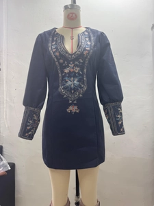 Detail of vintage floral embroidery on navy blue V-neck mini dress with puff sleeves