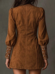 Macro detail of caramel suede dress showing vintage embroidery on the sleeve and stitching