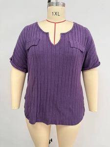 Close-up of V-neckline and decorative pockets on purple ribbed plus size top
