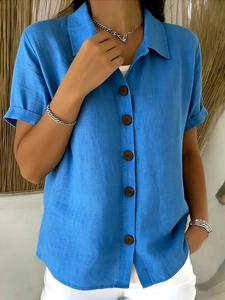 Close-up of sky blue linen shirt featuring classic lapel collar and dark brown buttons