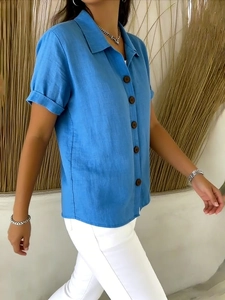 Detail of royal blue linen shirt featuring a lapel collar and dark wooden buttons