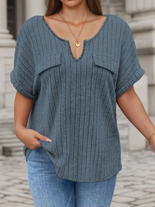 Detail of navy blue V-neck ribbed top with decorative flap pockets and rolled sleeves