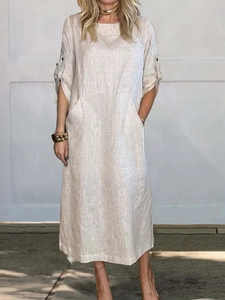 Detail view of light beige linen midi dress showing large utility pockets and adjustable sleeves