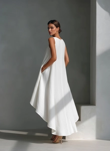 Detail view of white linen dress showing sleeveless design and asymmetric high-low hemline