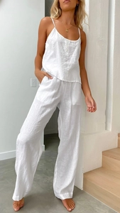 Details von weißem Baumwoll-Leinen-Set mit Camisole-Knöpfen und Textur der weiten Hose
